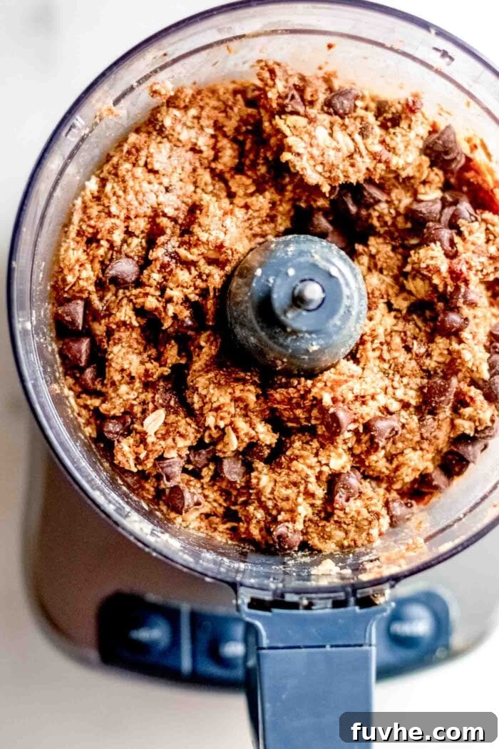 Deliciously Simple No Bake Granola Bars 5 Thick dough with chocolate chips in a food processor.
