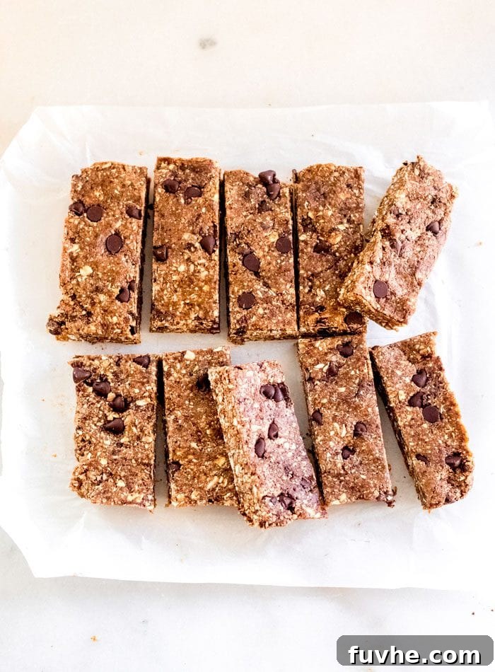 Deliciously Simple No Bake Granola Bars 7 A batch of no-bake granola bars that's been sliced into 10 equal-sized bars on a square of parchment paper.