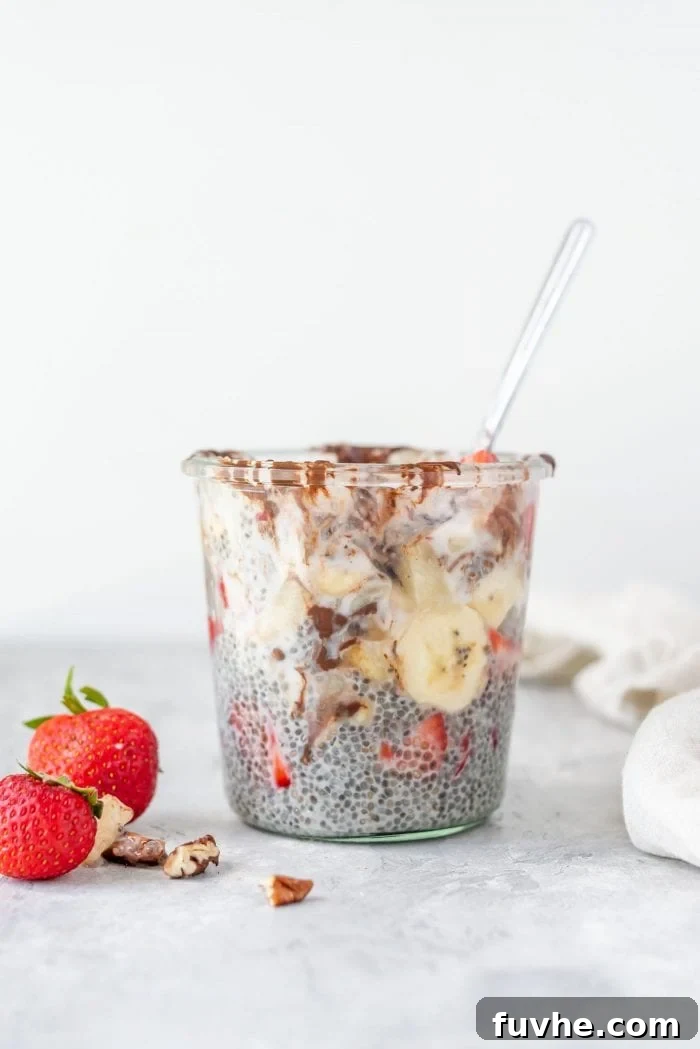 A vibrant chia seed pudding with banana slices and fresh strawberries, layered in a clear glass jar, ready to be enjoyed as a healthy snack or breakfast.