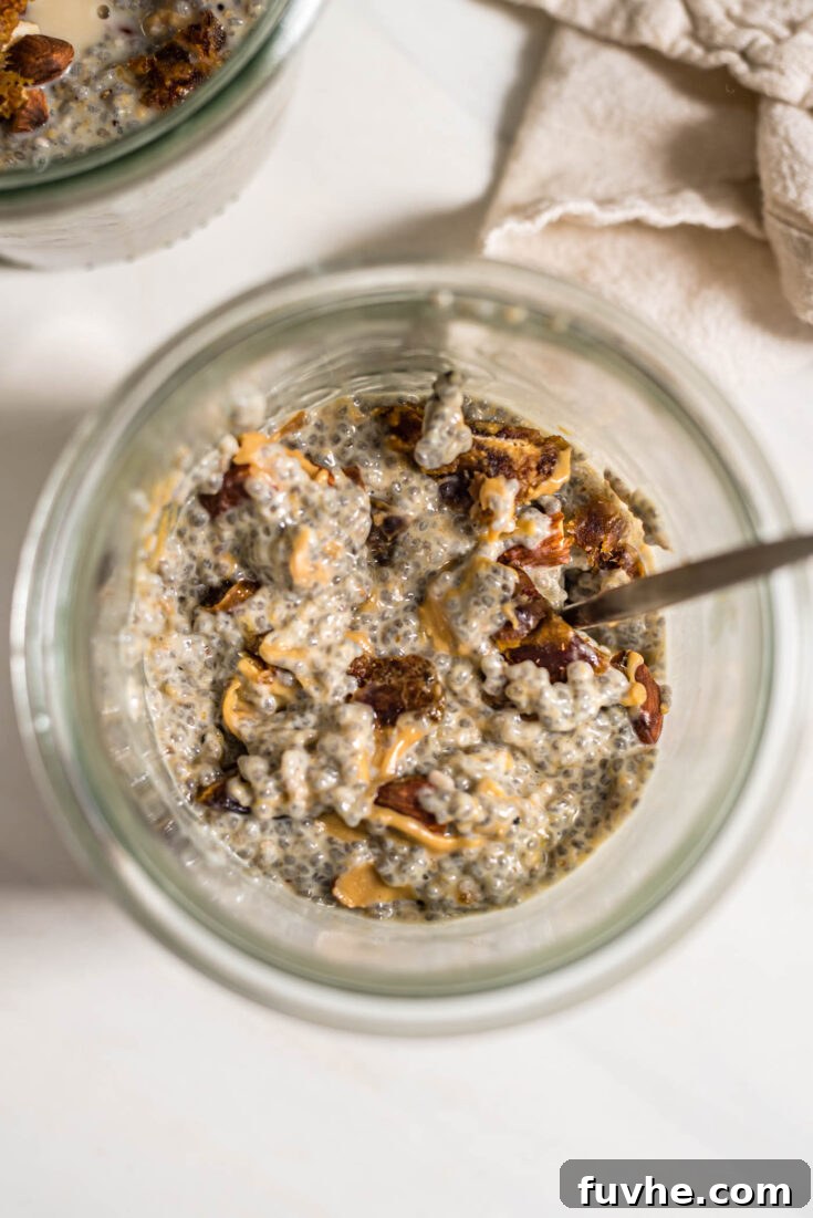 Sweet and Salty Peanut Butter Chia Seed Pudding in a glass, garnished with chopped peanuts and a date.