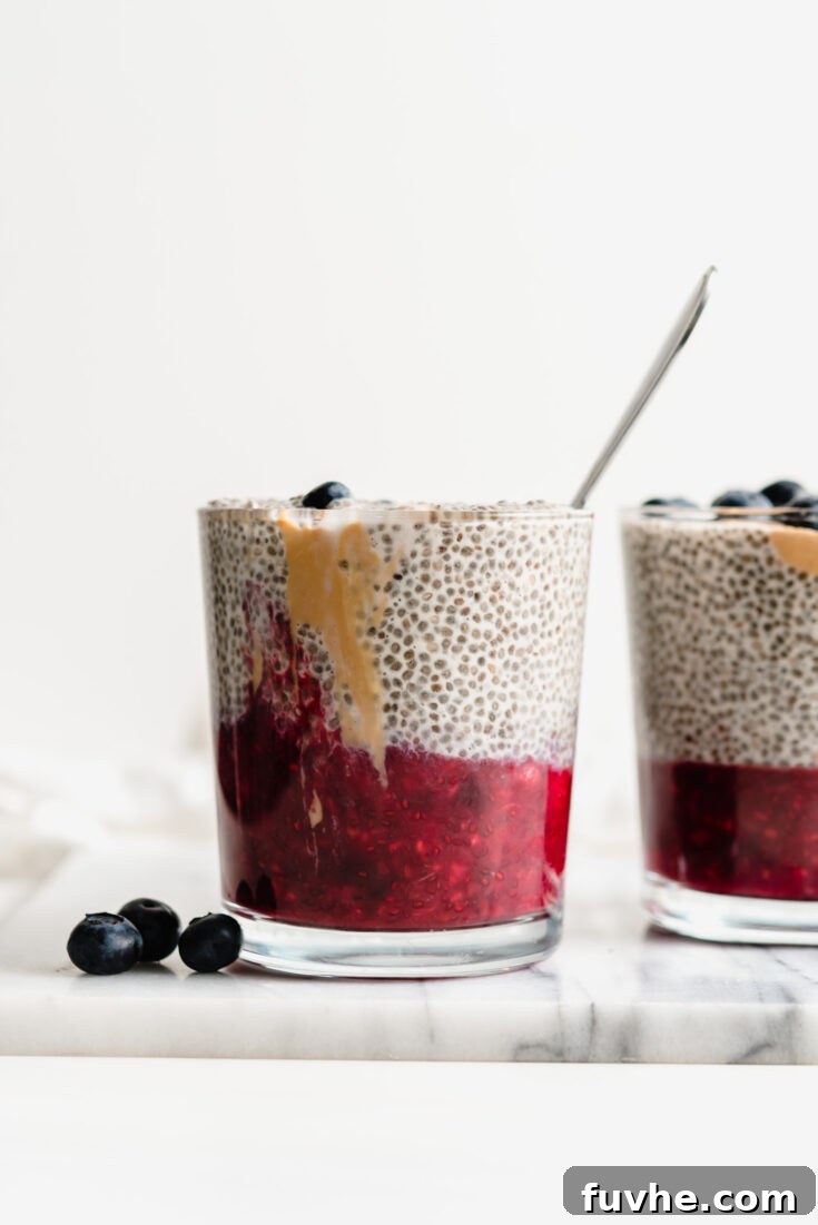 Peanut Butter Jelly Chia Pudding, layered with creamy peanut butter chia and vibrant berry jam in a glass jar.