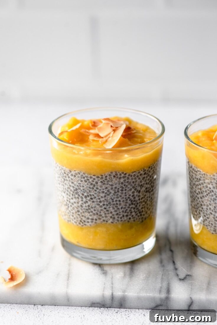 Bright and sunny Mango Chia Pudding in a glass with fresh mango slices and mint garnish.