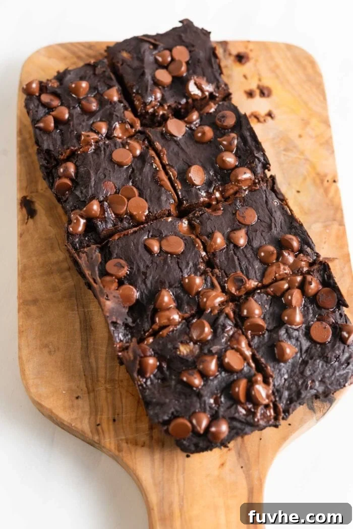 Plant-Powered Protein Brownies 7 A tray of chocolate chip brownies cut into 8 perfect pieces on a cutting board, ready to be enjoyed.