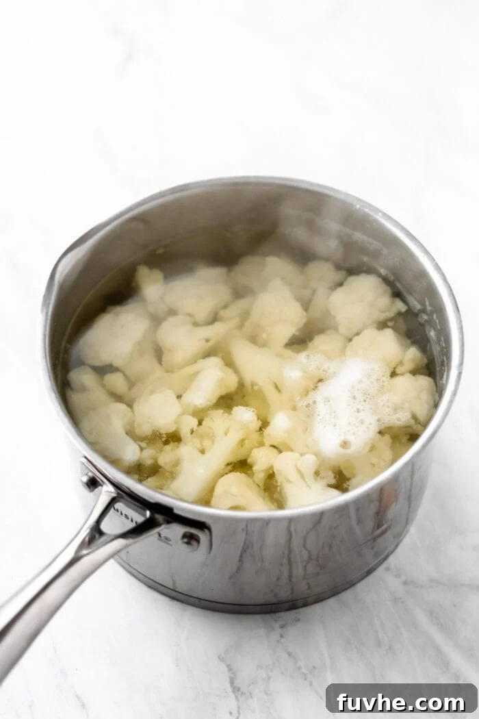 Cooked cauliflower florets in a pot of boiling water.