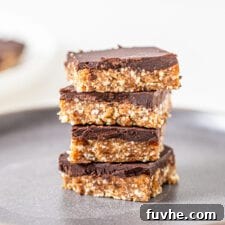 Stack of 4 chocolate-coated cashew cookie dough bars, representing the final delicious product, with a smooth chocolate top and a creamy, light-colored base.