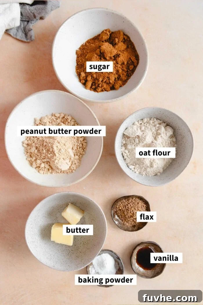 Scrumptious Peanut Powder Cookies 3 A flat lay image displaying all the essential ingredients for making vegan peanut butter powder cookies, with each item clearly labelled and organized.
