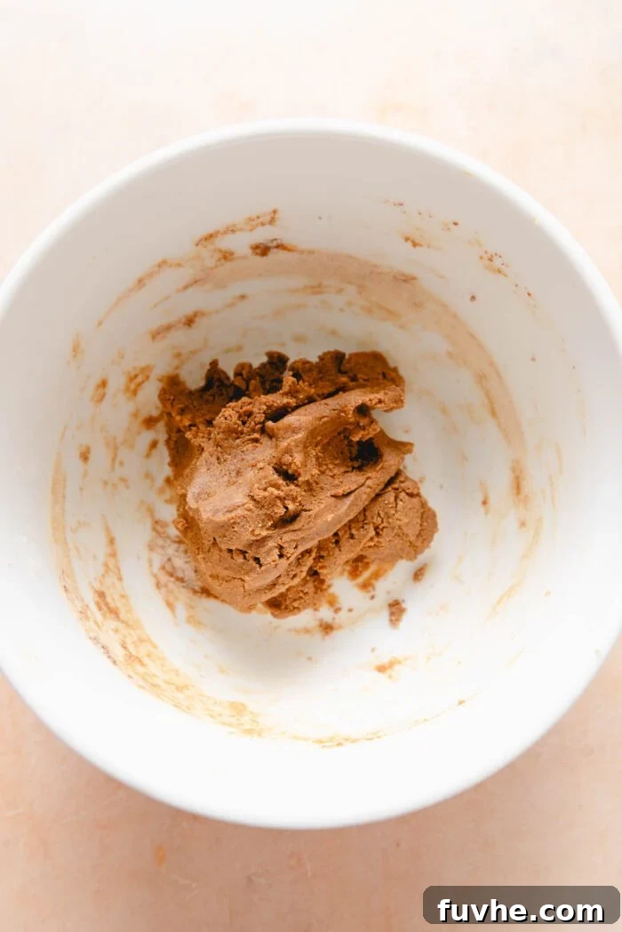 Scrumptious Peanut Powder Cookies 6 The full cookie dough mixture, featuring powdered peanut butter and oat flour, appears uniform and well-combined in a mixing bowl.