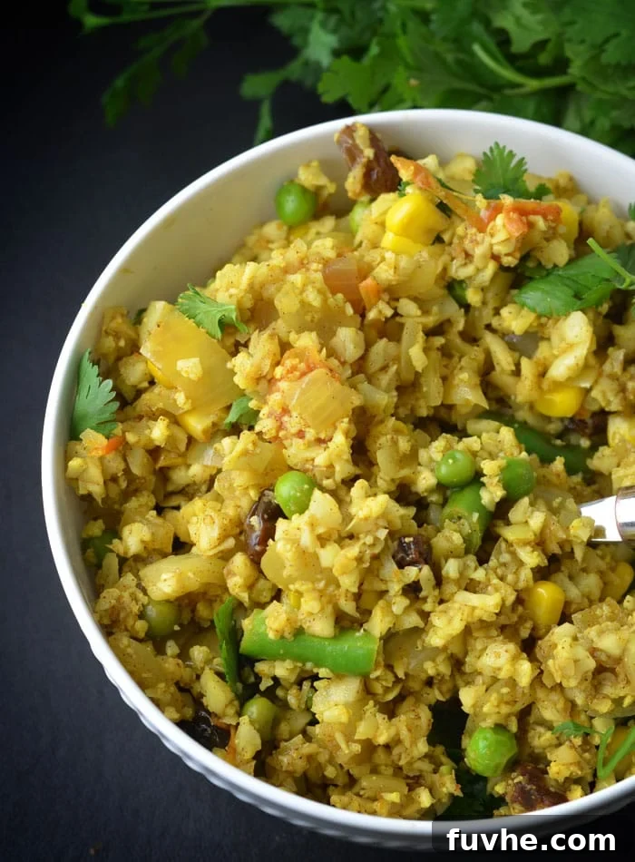Mastering Macros: 23 Vegan Meals and Snacks 6 Indian-spiced cauliflower rice, a flavorful and macro-friendly vegan meal with peas, tomatoes, and raisins.