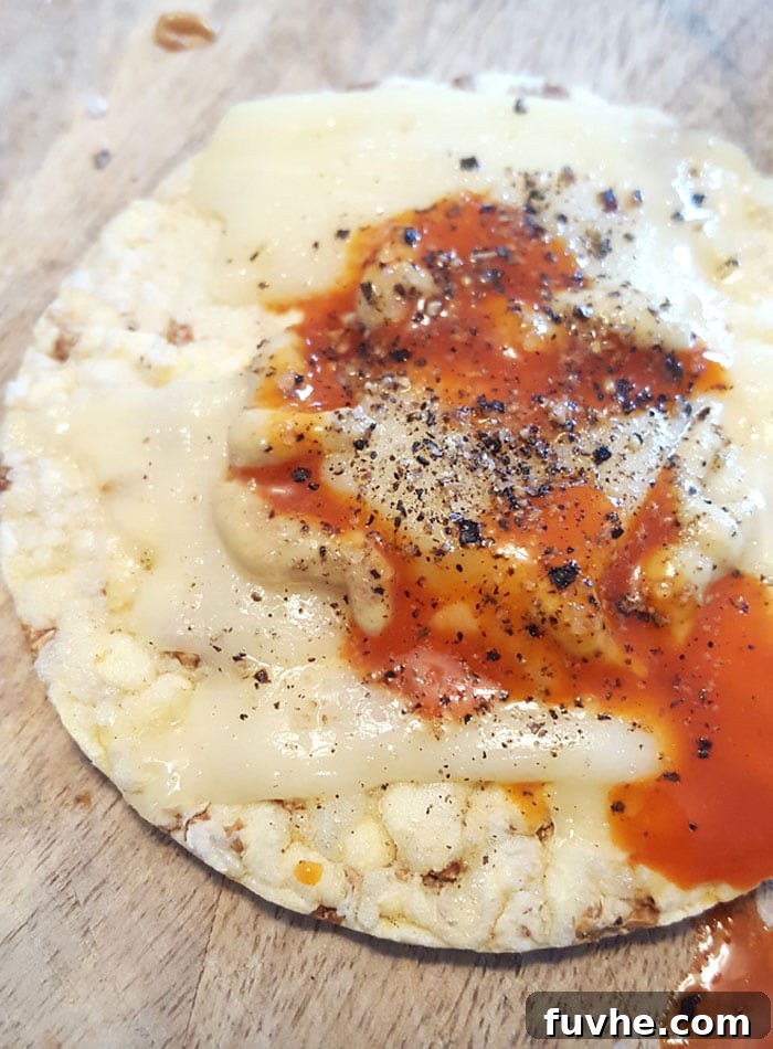 Mastering Macros: 23 Vegan Meals and Snacks 7 Rice cakes topped with melted vegan provolone cheese, hot sauce, and dijon mustard, a unique vegan snack.