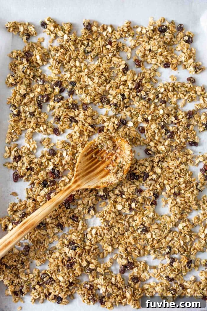 Guilt-Free Granola Crunch 4 The granola mixture is evenly spread on a baking tray, ready to be baked into crunchy clusters.