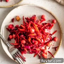 Beet, carrot and chickpea salad on a plate with a fork.