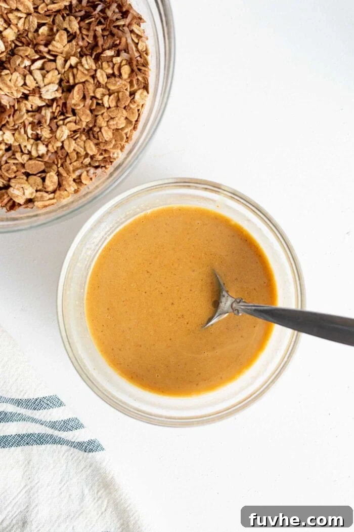A spoon dipping into a bowl of smooth, creamy peanut butter, highlighting its rich texture.