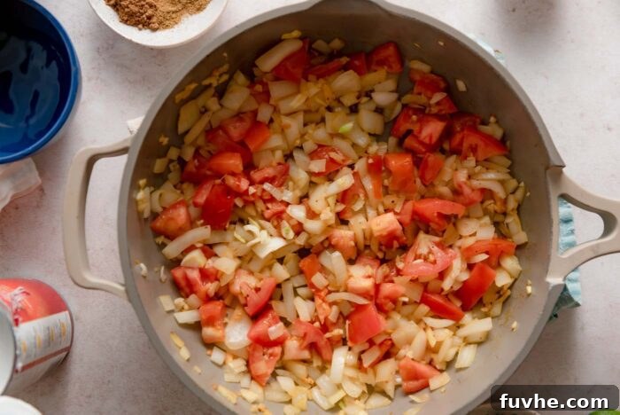 Tomato, onion and garlic cooking in a skillet.