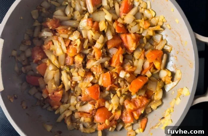 Onion, garlic, ginger, tomato and spices cooking in a pan.