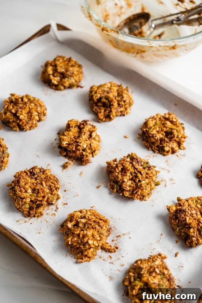 Sweet Potato Spice Cookies 6 Raw sweet potato cookie dough scooped onto a parchment paper-lined baking tray, ready for baking.