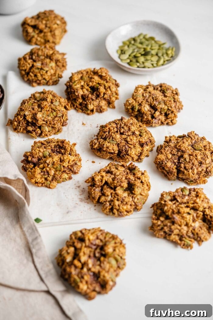 Sweet Potato Spice Cookies 7 A number of perfectly baked sweet potato cookies on a piece of parchment paper beside a small dish of pumpkin seeds, ready to be enjoyed.