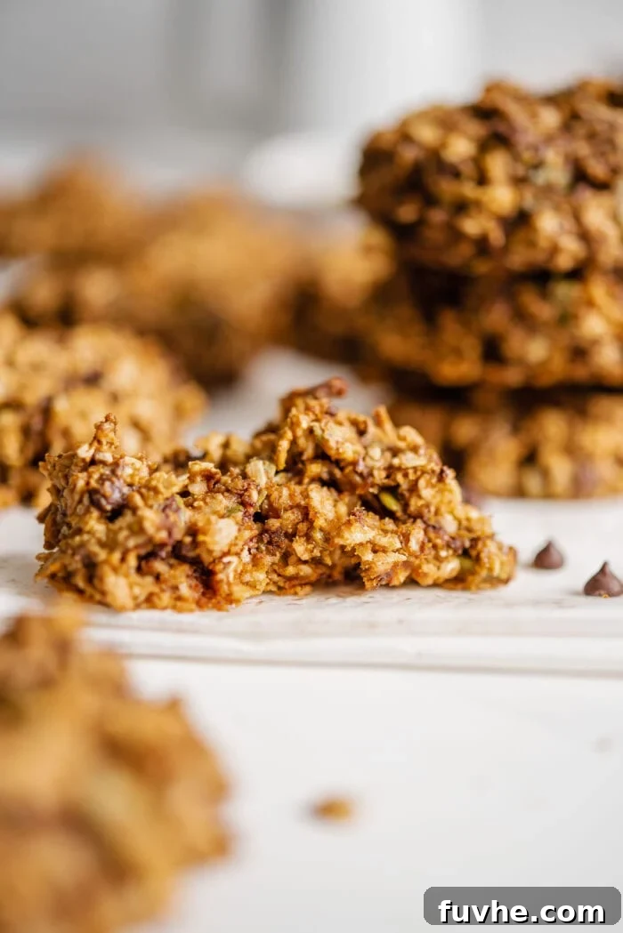 Sweet Potato Spice Cookies 8 Close up of a vegan sweet potato cookie with a bite out of it to show inside texture, revealing oats and chocolate chips.