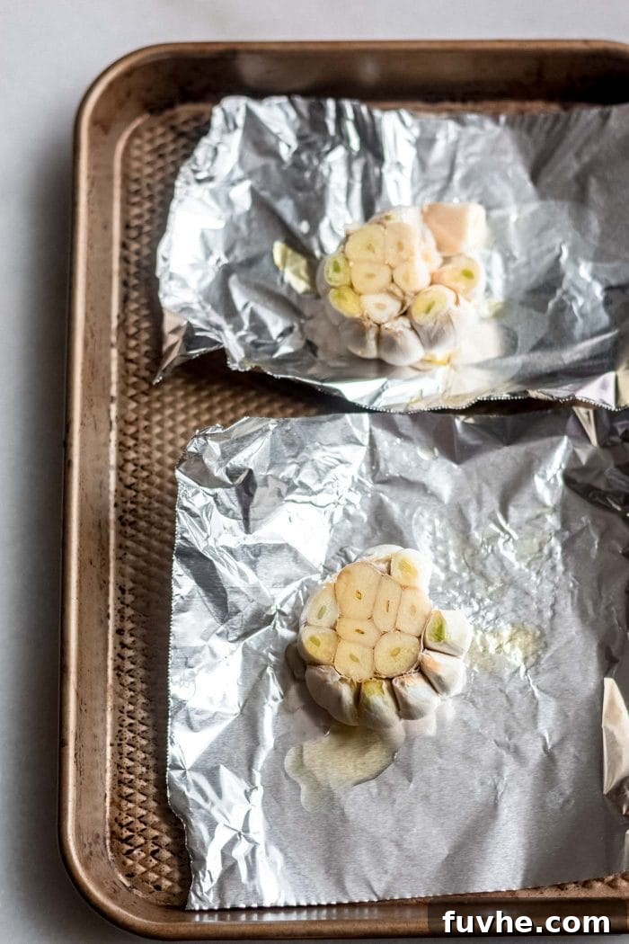 Golden Roasted Garlic Cauliflower Soup 3 Two bulbs of garlic prepared for roasting in aluminum foil with olive oil.