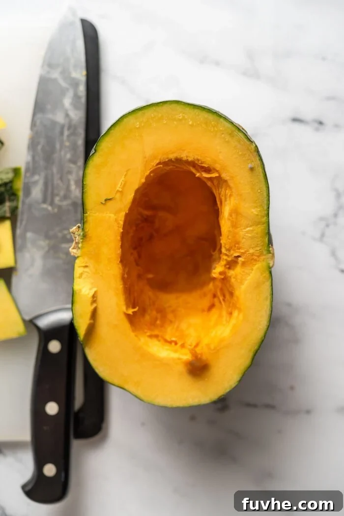 Spiced Kabocha Delight 4 A kabocha squash expertly cut in half on a wooden cutting board, with its seeds and internal fibers carefully removed, ready for further preparation.