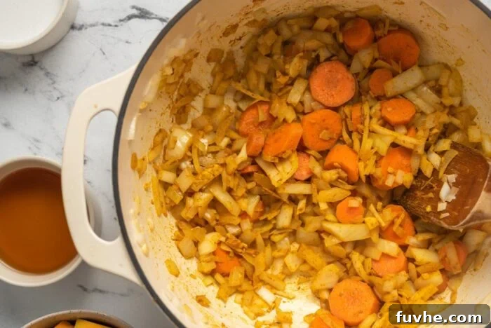 Silken Kabocha Squash Soup 7 The aromatic blend of onion, garlic, ginger, and carrots now enhanced with a generous sprinkle of spices, continues to cook in a large soup pot.