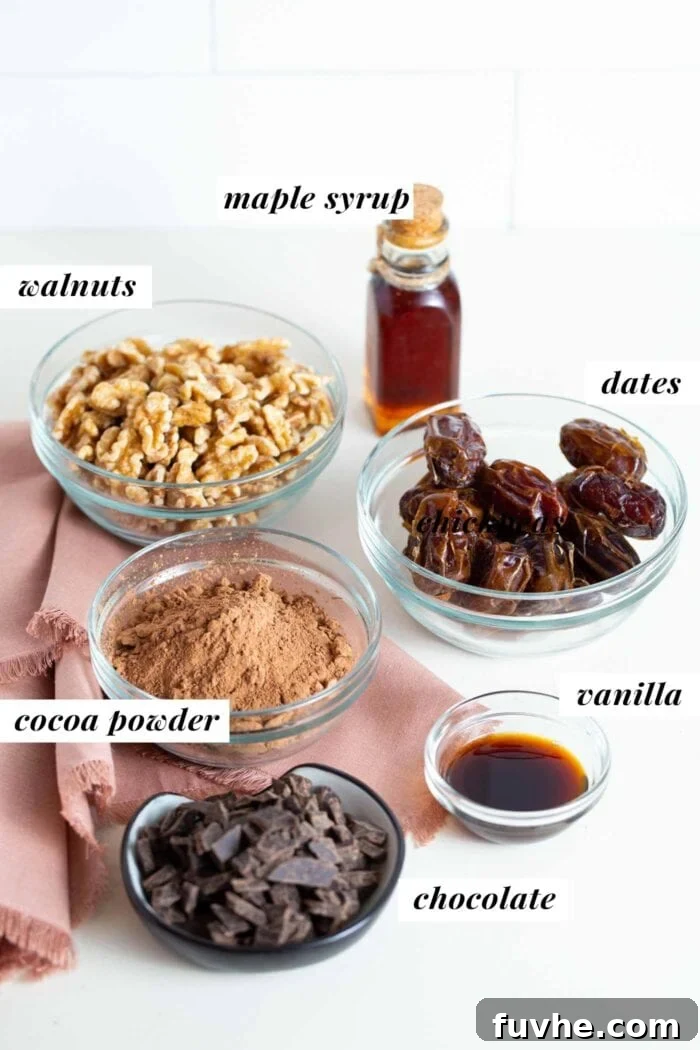 Separated ingredients for raw vegan brownies, including chocolate chunks, cocoa powder, walnuts, dates, and vanilla extract in small containers.