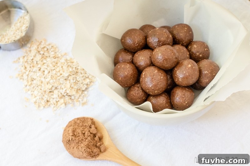 Gluten-free chocolate balls rolled uniformly and placed in a lined bowl. 