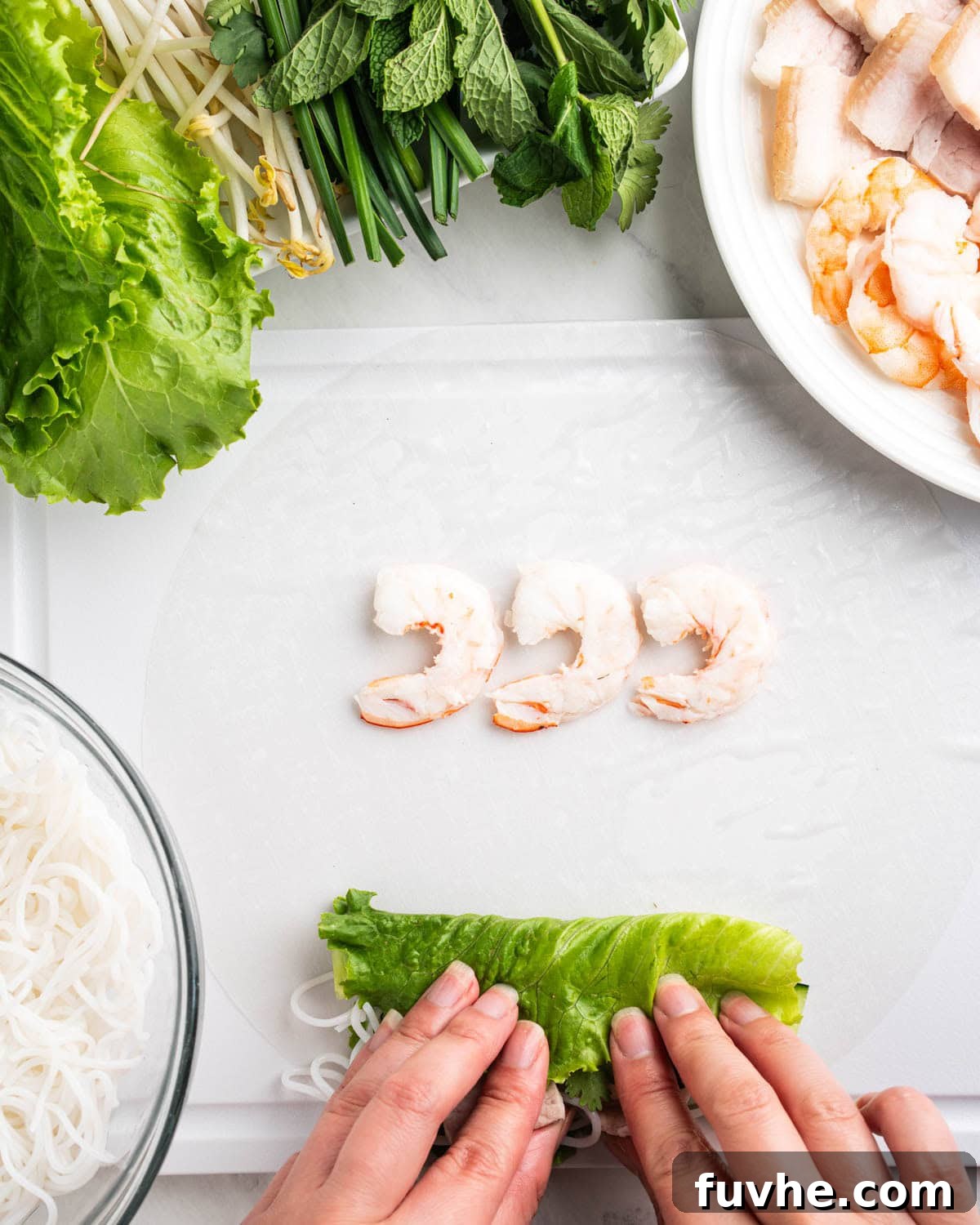 Vietnamese Fresh Spring Rolls (Gỏi Cuốn) — Authentic Recipe 11 hands tucking in lettuce and herbs, shrimp placed at top of rice paper.