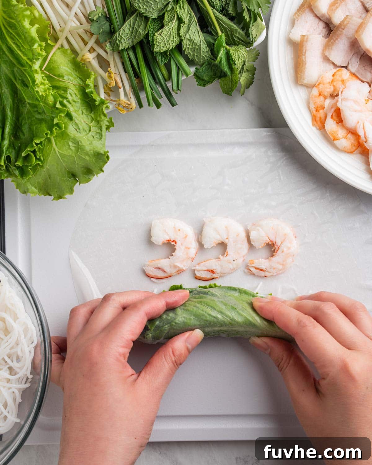 Vietnamese Fresh Spring Rolls (Gỏi Cuốn) — Authentic Recipe 12 hands tucking in lettuce, herbs and noodles folding towards the shrimp on edge of rice paper.
