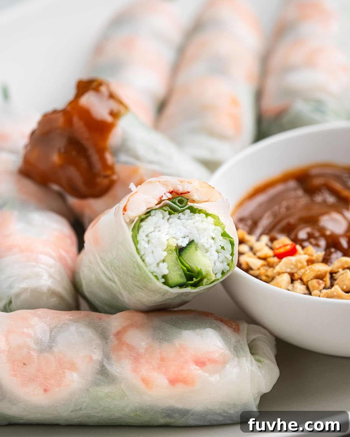 Vietnamese Fresh Spring Rolls (Gỏi Cuốn) — Authentic Recipe 18 Cross section of spring roll to show inside. Other half dipped in peanut sauce.